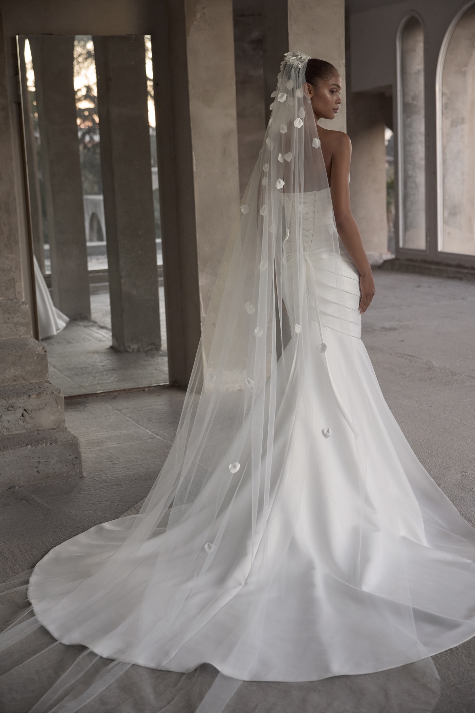 Sposa con abito contemporaneo e lungo velo floreale